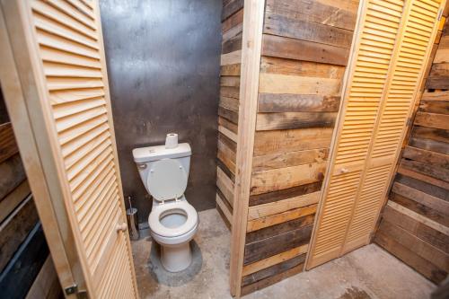 a bathroom with a toilet in a wooden stall at PodShare DTLA in Los Angeles