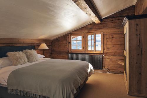 a bedroom with a large bed and wooden walls at Le Chalet Lion Rouge in Rougemont