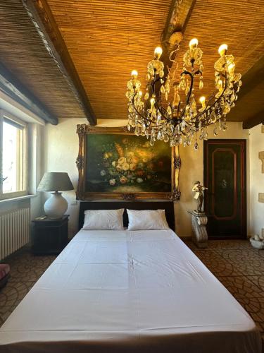 ein Schlafzimmer mit einem großen weißen Bett mit einem Kronleuchter in der Unterkunft nicolashouse on the sea 2 in Bari
