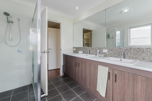 a bathroom with two sinks and a shower at Dual Ensuite Coopers Plains Home by QEII, QSAC and Griffith Uni in Brisbane