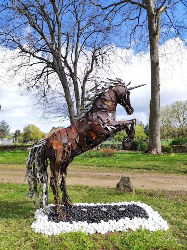 a statue of a horse standing in the grass at Chambres d'hôtes du domaine de l'Isle in Civray-de-Touraine