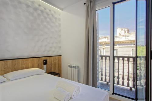 a bedroom with a bed and a large window at Fontanella Green House in Barcelona