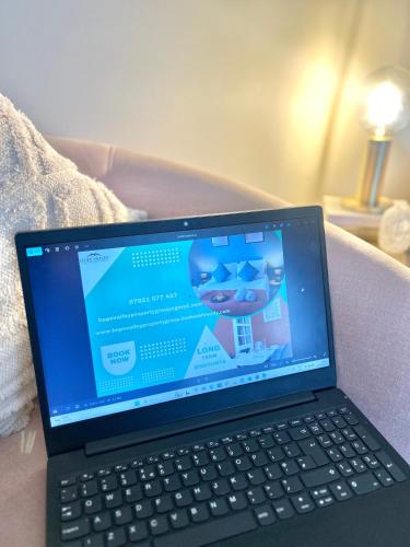 a laptop computer sitting on top of a couch at Hope Cottage In Slough With Parking in Slough