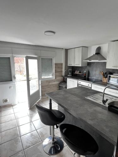 - une cuisine avec un comptoir et une chaise noire dans l'établissement Small house with garden, à La Celle-sous-Gouzon