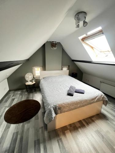 une chambre mansardée avec un lit et une fenêtre dans l'établissement Small house with garden, à La Celle-sous-Gouzon