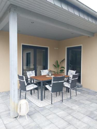 a wooden table and chairs on a patio at Ferienhaus Seeliebe in Krugsdorf