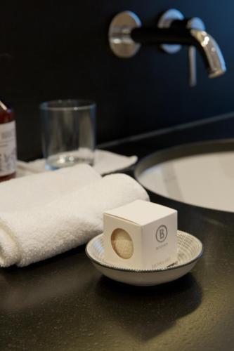 a bathroom counter with a plate with a box on it at ANGELA Landhaus Fine Serviced Apartments and Double Rooms in Lech am Arlberg