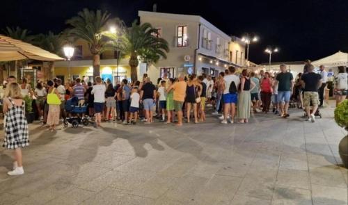 a crowd of people standing in a street at night at Gamm Simius Home Holiday in Villasimius