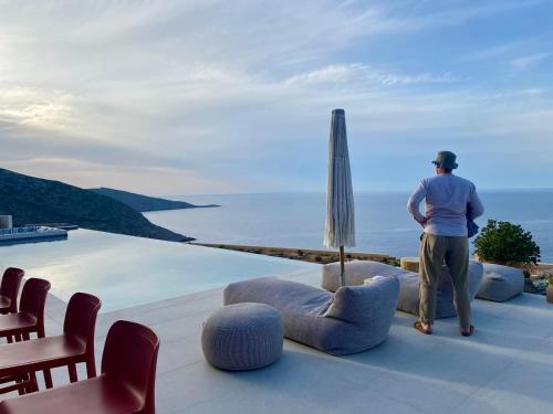 a man standing on a roof looking out at the ocean at Maison Meltem in Agia Pelagia