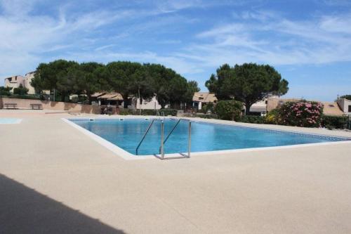une piscine vide avec des arbres en arrière-plan dans l'établissement SP320-629 Appt 2 pièces 4 couchages SAINT PIERRE LA MER, à Saint Pierre La Mer