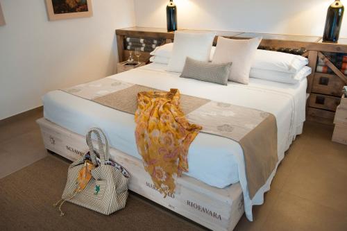 a bedroom with a large bed with a scarf on it at Riofavara Winery in Val di Noto in Ispica