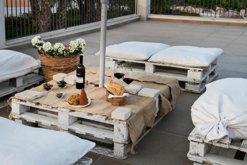 a table with flowers and wine bottles on top of pallets at Riofavara Winery in Val di Noto in Ispica