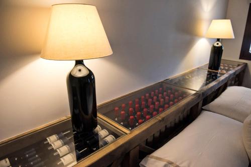 a room with a table with a lamp next to a bed at Riofavara Winery in Val di Noto in Ispica