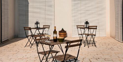a patio with a table with bottles and chairs at Riofavara Winery in Val di Noto in Ispica