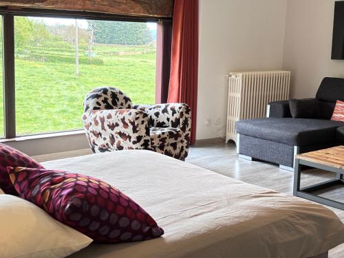 a bedroom with a bed and a chair and a window at domaine du vernay in Mazille