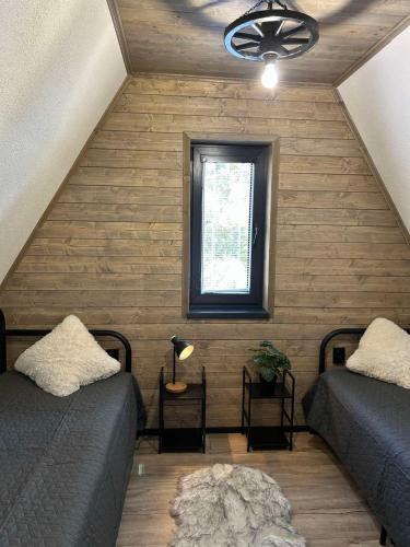 a attic room with two beds and a window at Chata Bosorečka in Smižany