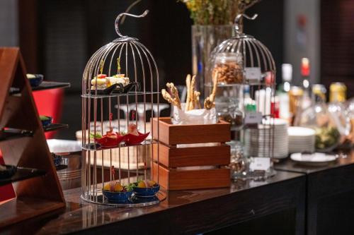 a table with two bird cages filled with food at Xiamen C&D Hotel-Free Welcome Snacks-Oasis Garden in Xiamen