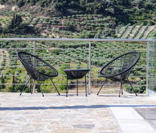 two black chairs sitting in front of a vineyard at ReCrete - Retreat in Crete in Heraklio Town