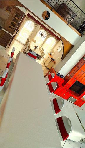 a living room with a table and red chairs at Luxuriöse Villa Romantica in Gampel