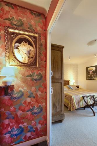 a bedroom with a painting on the wall and a bed at Hôtel Diderot in Chinon