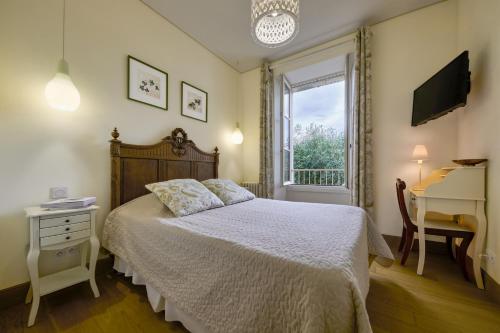 a bedroom with a bed and a desk and a window at Hôtel Diderot in Chinon