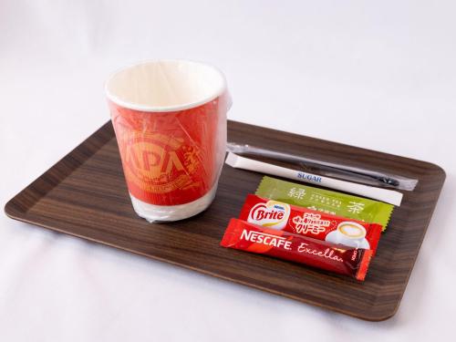 a tray with a cup of coffee and some snacks at APA Hotel Higashi Shinjuku Kabukicho Higashi in Tokyo