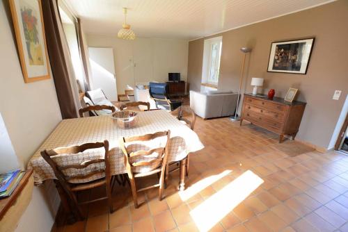 une salle à manger avec une table et des chaises et un salon dans l'établissement Les Bardilles-Maison de campagne-3km du centre de Sarlat, à Sarlat-la-Canéda
