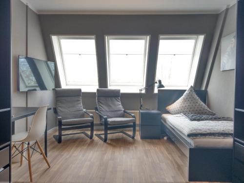 a bedroom with two chairs and a bed and a desk at Apartment I Lausitzring I BASF in Schipkau