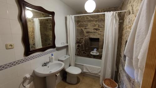 a bathroom with a sink and a toilet and a shower at Casa de Turismo Rural Os Petroglifos in Boiro