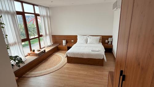 Ðình LoanにあるZenocean homestayのベッドと大きな窓のある寝室