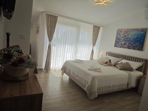 a bedroom with a bed and a large window at Apartment Topic in Baška Voda