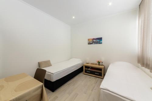 a small room with two beds and a table at E-home Apartments in Varna City