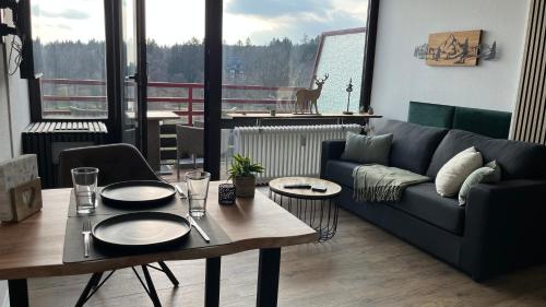 a living room with a couch and a table at Ferienwohnung Panoramablick Hahnenklee in Hahnenklee-Bockswiese