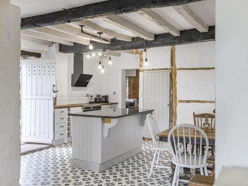 cocina con encimera y sillas en una habitación en 6 Bedroom Country Cottage with Hot Tub, en Shifnal