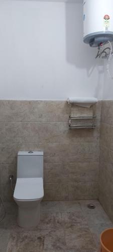 a bathroom with a white toilet in a room at Cozy haven stays in Prayagraj