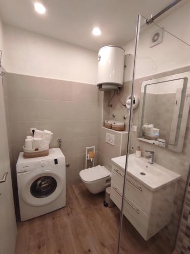 a bathroom with a washing machine and a sink at Apartment Topic in Baška Voda