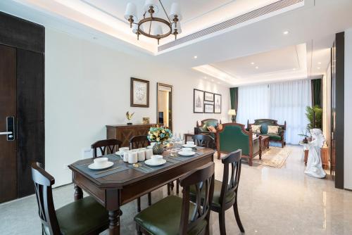 a dining room and living room with a table and chairs at 三亚海棠湾蔚蓝海湾公寓 in Sanya
