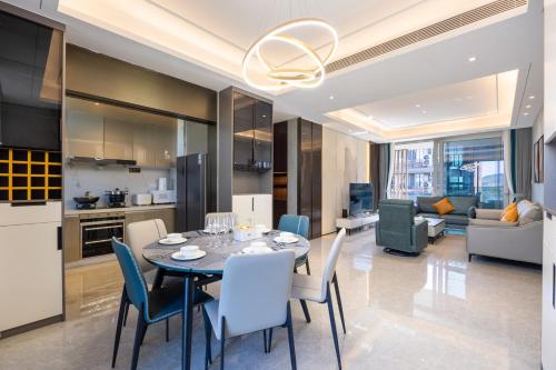 a dining room and living room with a table and chairs at 三亚海棠湾蔚蓝海湾公寓 in Sanya