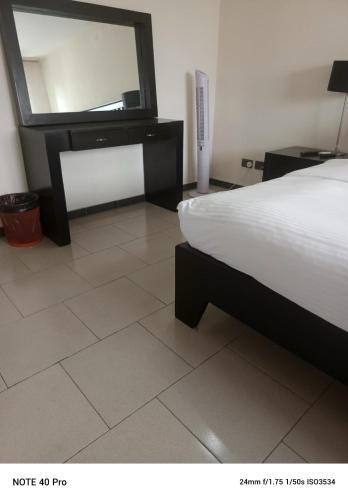 a bedroom with a bed and a dresser and a mirror at Emem Court in Lagos