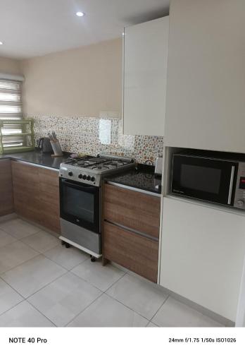 a kitchen with a stove and a microwave at Emem Court in Lagos