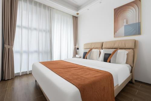 a bedroom with a large bed and a large window at 三亚海棠湾蔚蓝海湾公寓 in Sanya
