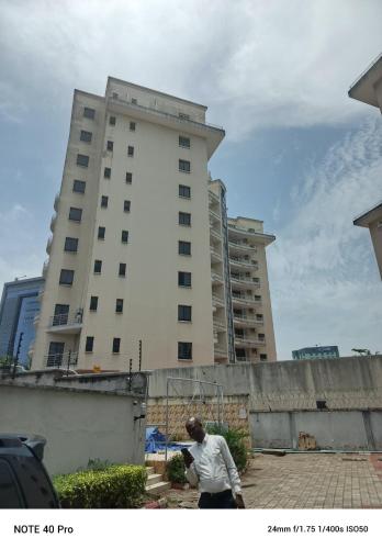 a man flying a kite in front of a tall building at Emem Court in Lagos