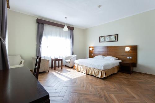 a hotel room with a bed and a desk and chair at شـاطئ الجـار in Rayyis