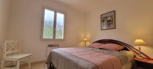 - une chambre avec un lit doté d'oreillers roses et d'une fenêtre dans l'établissement Famille et nature aux portes du Luberon, à Apt