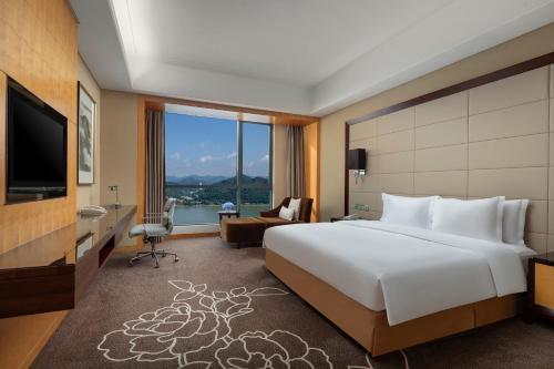 a hotel room with a large bed and a television at Crowne Plaza Yichang by IHG in Yichang