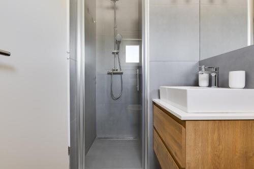 een badkamer met een douche en een witte wastafel bij Villa Grigia in Banjevci