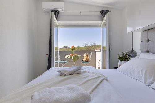 een slaapkamer met een bed met uitzicht op de oceaan bij Villa Grigia in Banjevci