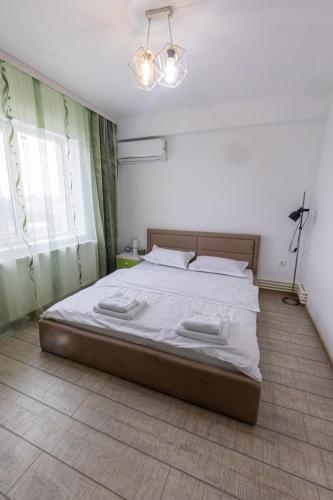 a bedroom with a large bed with white sheets at MaraM in Constanţa