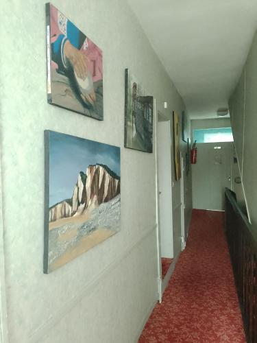 un couloir avec trois photos sur le mur dans l'établissement Les voyageurs, à Magnac-Bourg