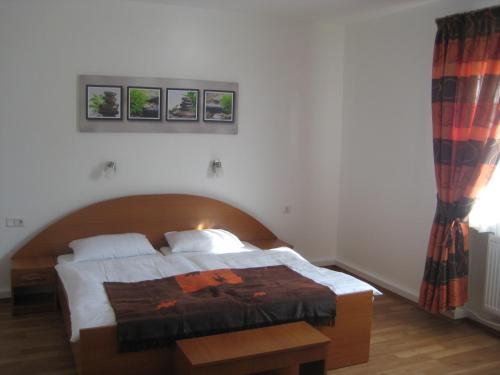 ein Schlafzimmer mit einem Bett mit einem Kopfteil aus Holz in der Unterkunft Bliestal Hotel in Blieskastel